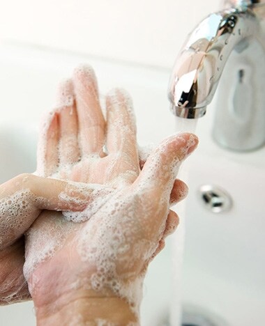 Hygiëne concept. handen wassen met zeep onder de kraan met water